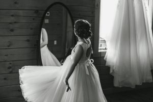 Black and white photo of person twirling in tulle wedding dress.