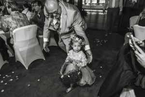 Black and white photo of dancing at a wedding reception with confetti scattered on the floor.