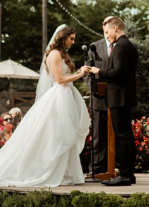 A couple exchanges rings during their outdoor garden wedding ceremony.