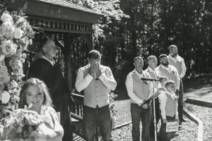 Black and white photo of a wedding ceremony with guests gathered outdoors.