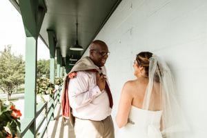 Emotional moment captured during wedding preparations on covered porch.