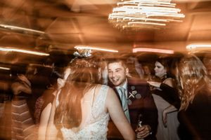 Festive wedding reception dance party with motion blur and ambient lighting.