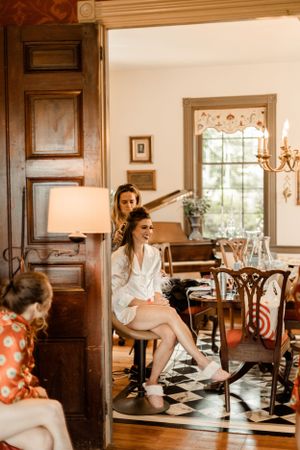 Getting ready scene in vintage room with checkered floor and traditional furniture.