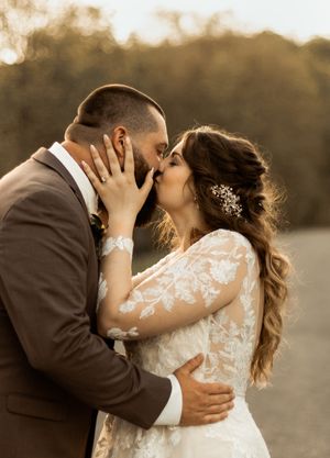 Romantic sunset wedding portrait of couple sharing intimate moment.