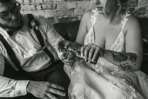 Black and white intimate moment captured of a couple sharing a drink on their wedding day.