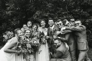 Black and white wedding party photo with playful poses.