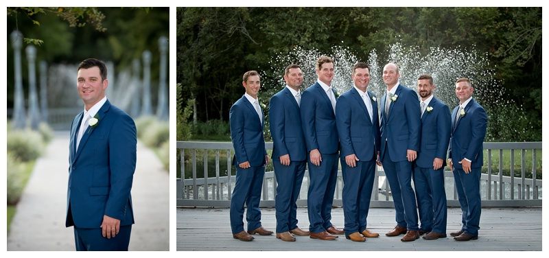Groomsmen in navy blue suits gather for formal portraits in an outdoor garden setting.