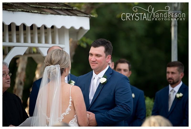 Wedding ceremony proceedings unfold beneath an elegant white gazebo.