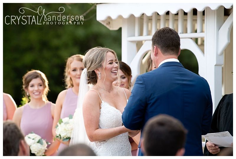 Joyful moment shared during wedding ceremony under white gazebo.