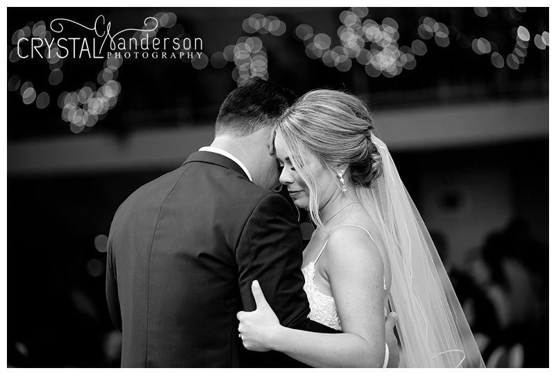 Newlyweds dancing close together during their wedding reception.