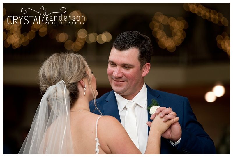 Wedding couple shares an intimate dance moment under soft lighting.