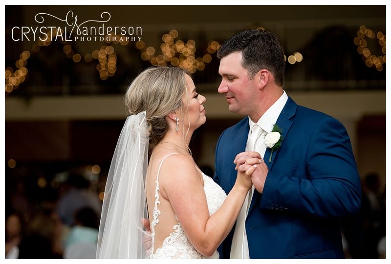 Couple embraces while slow dancing at an elegant wedding celebration.
