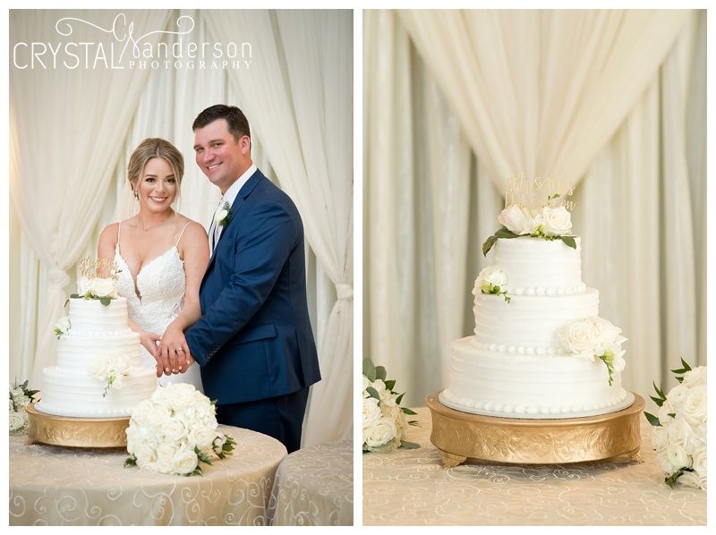 Elegant white wedding cake displayed with floral decorations on a gold stand.