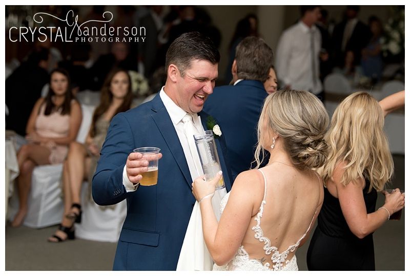 Wedding guests enjoying themselves while dancing at an indoor reception.