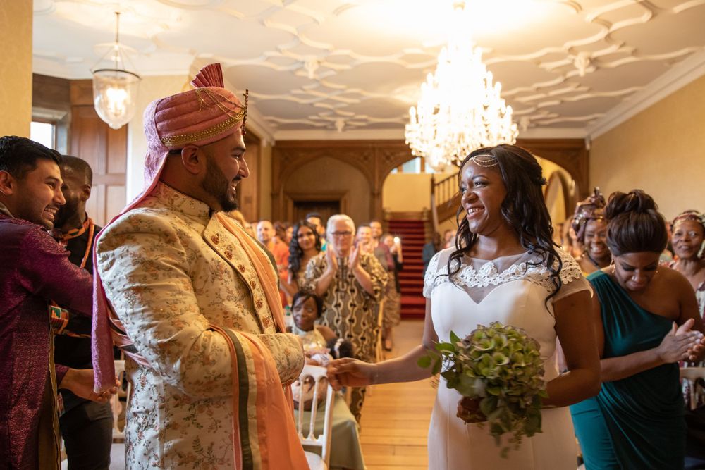 Wedding ceremony celebration in ornate ballroom with chandelier overhead.