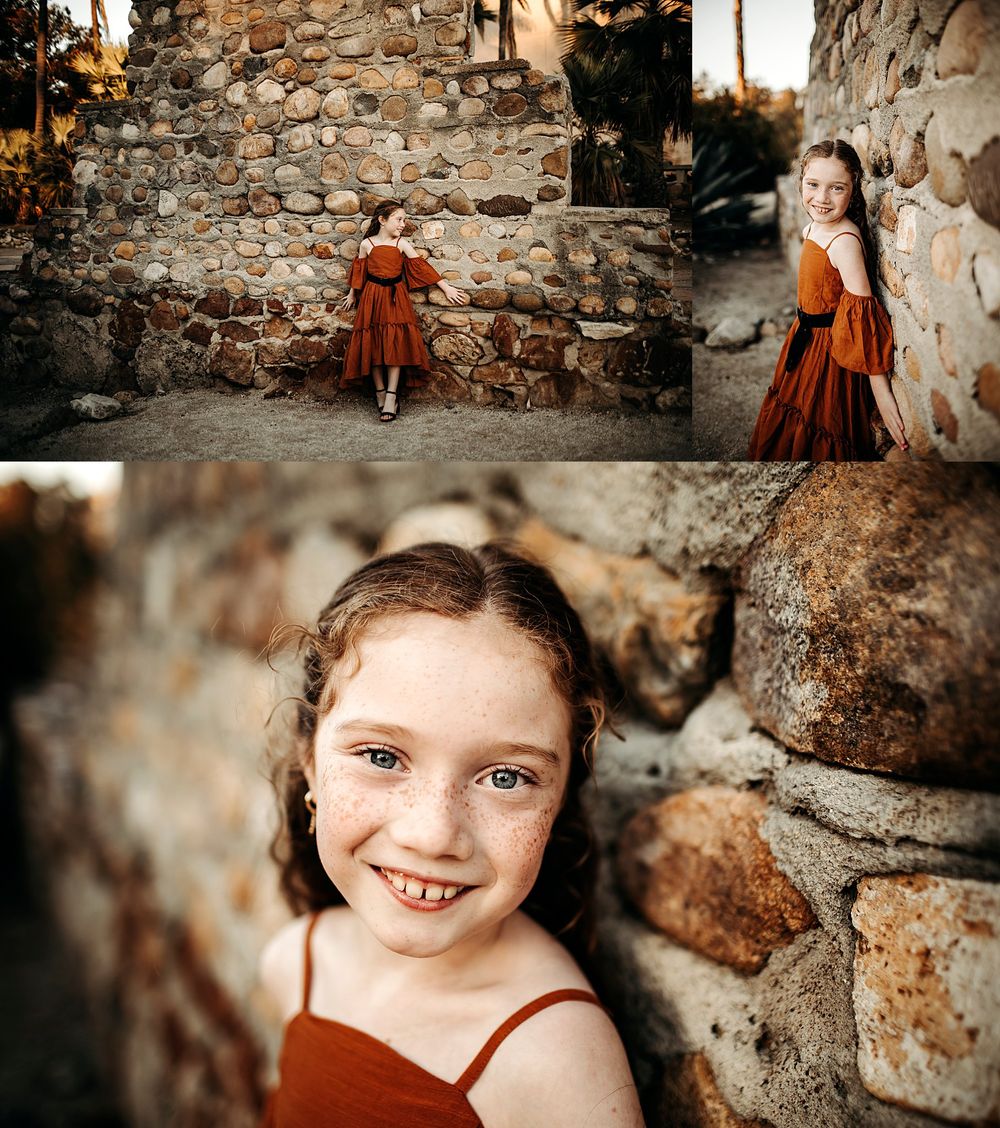 young girl wears bright dress and leans against stone wall by Danielle Miranda Photography