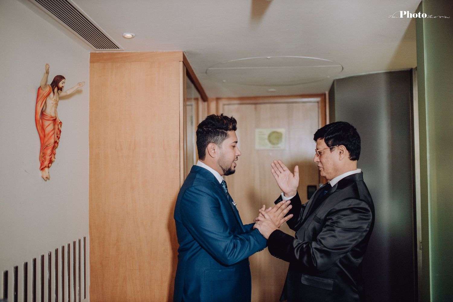 Celebratory gathering of formally dressed people in a modern hotel hallway.