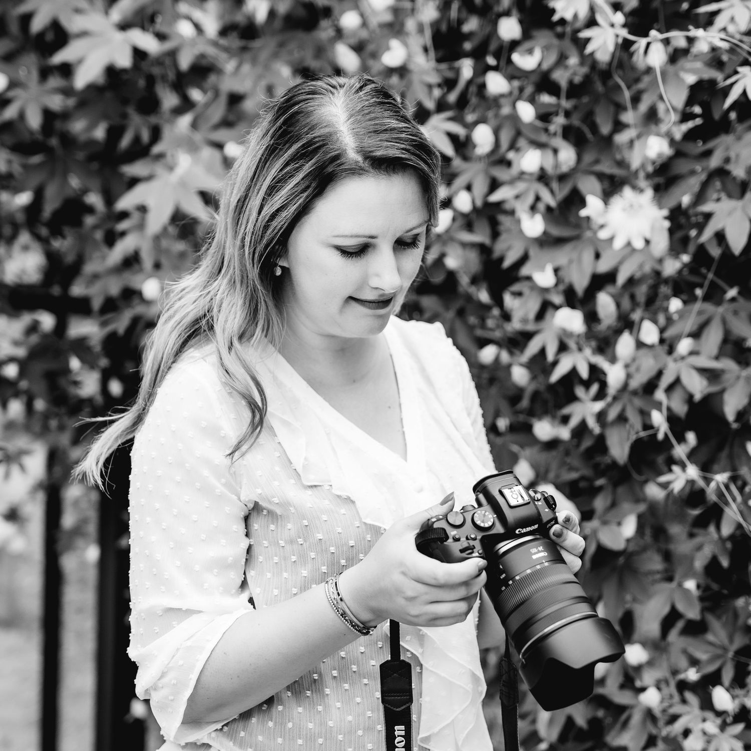 A series of black and white photos showing someone examining a vintage camera in a garden setting.