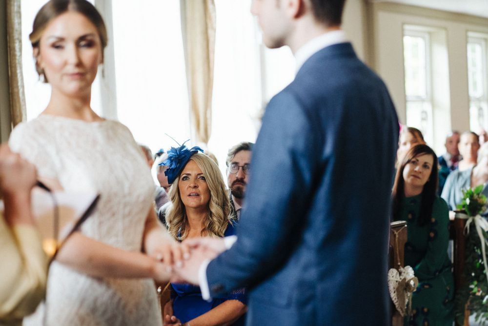A wedding ceremony scene showing guests reacting with joy during the service.