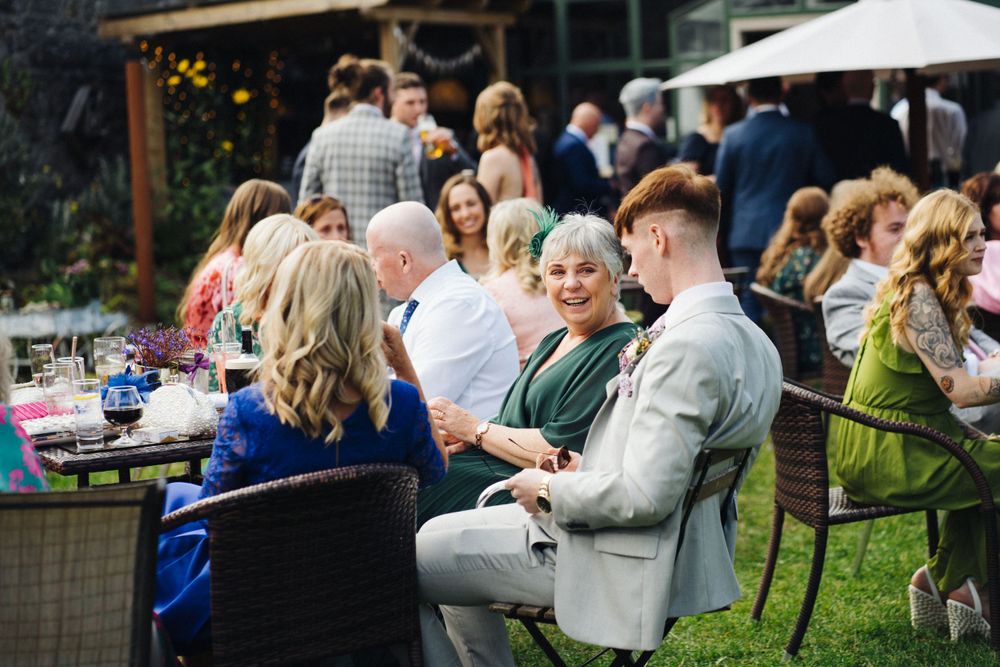 Wedding guests enjoying an outdoor reception with patio furniture.