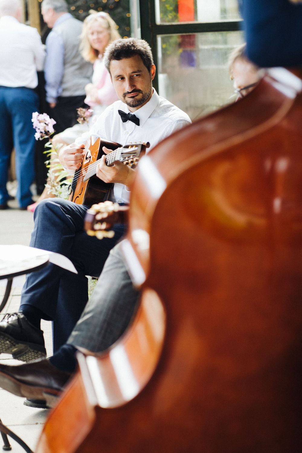 Musicians performing with acoustic instruments at outdoor gathering.