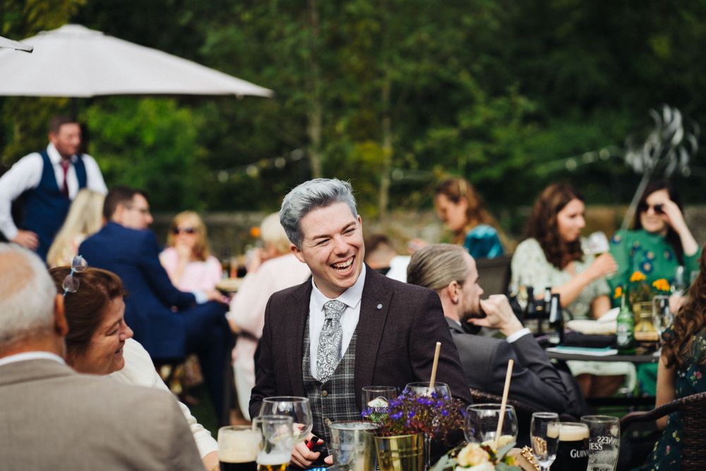 Wedding reception celebration with guests dining at outdoor tables.