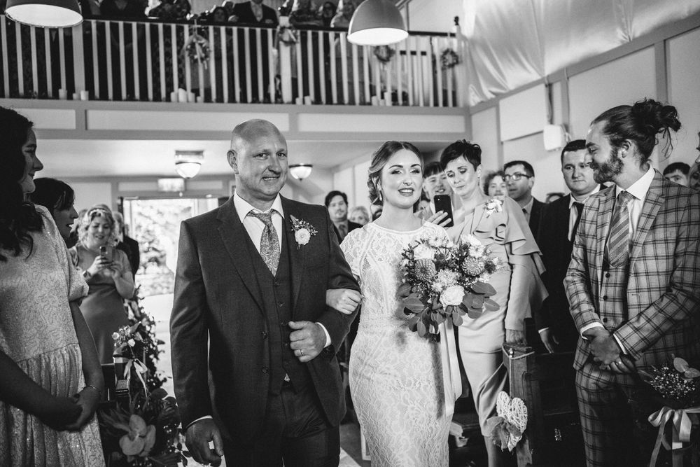 Two people share a lighthearted moment during a wedding ceremony.