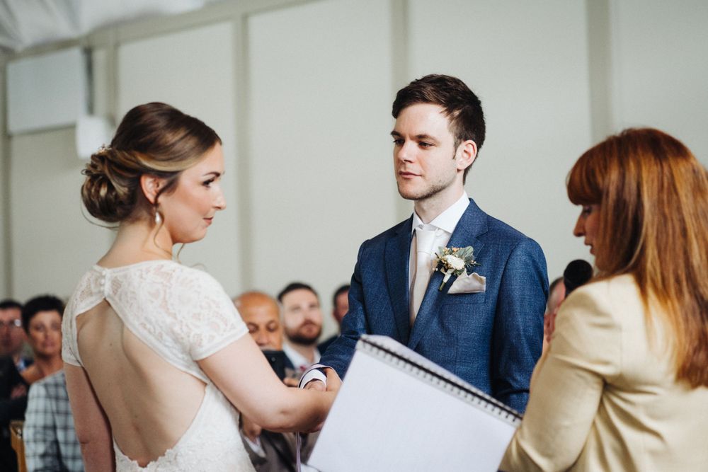 A wedding ceremony moment showing participants exchanging documents during the service.