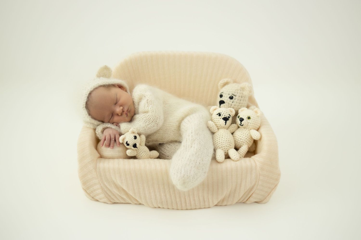 Sleeping newborn baby posed on miniature sofa during studio newborn session in Centurion with soft, timeless styling