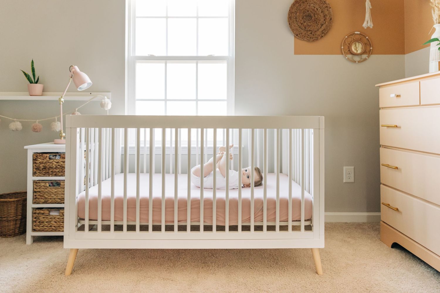 a baby girl lays in her crib for a Charlotte photo session