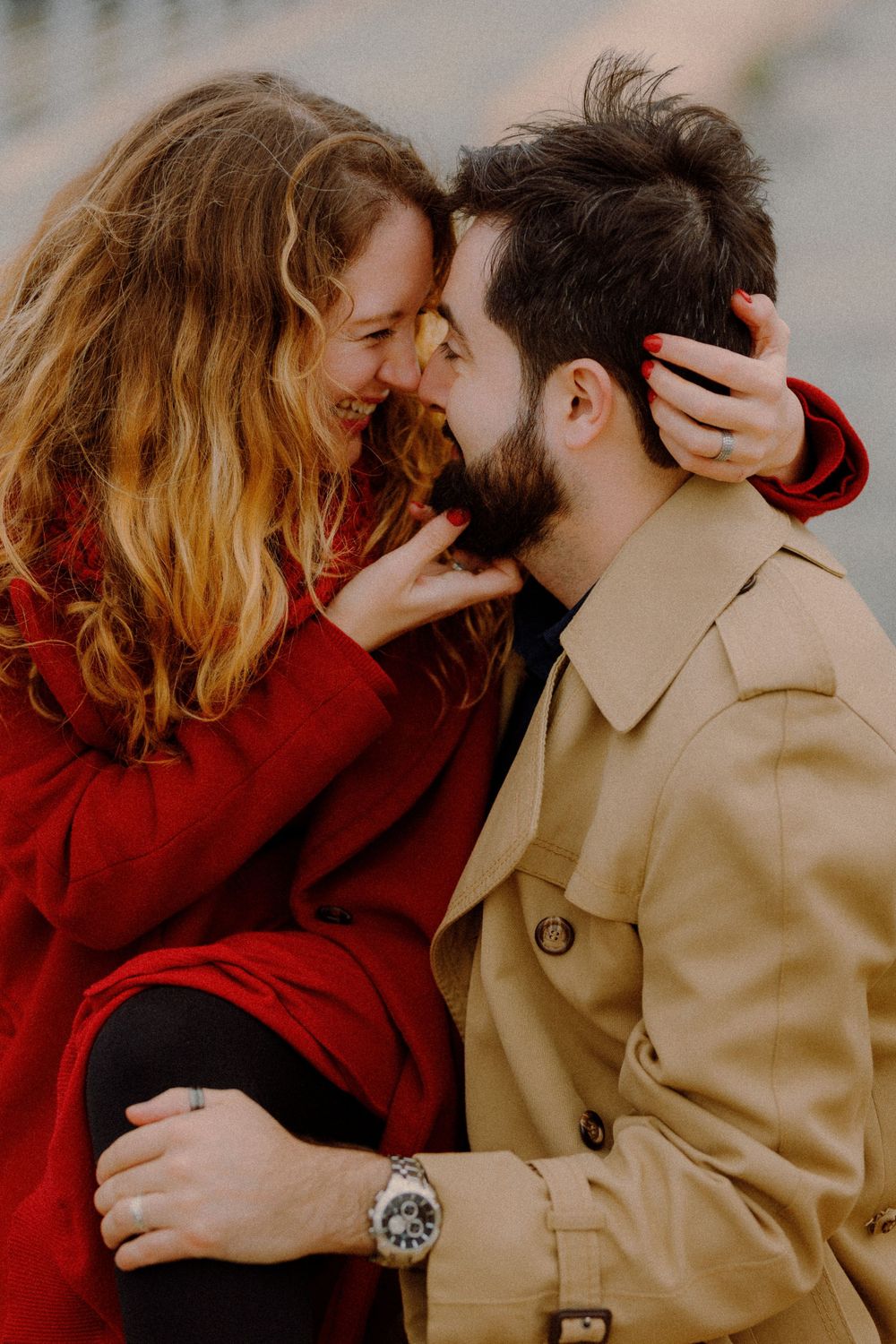 Close-up shot of romantic couple in warm winter coats sharing tender moment outdoors.