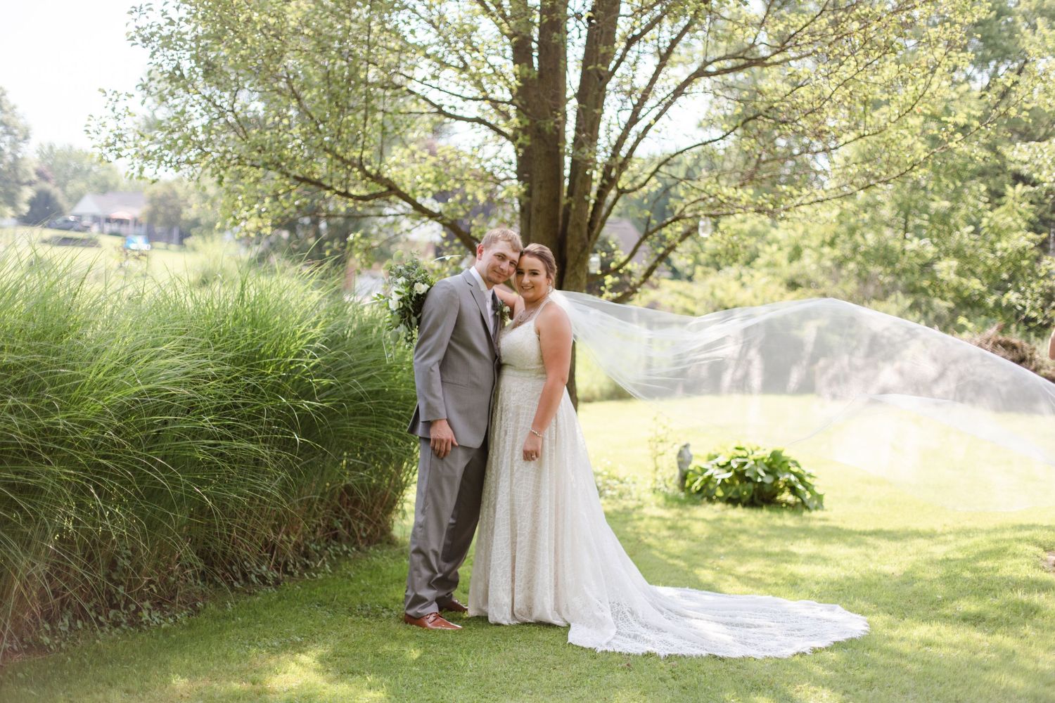 Romantic wedding photos captured in a lush garden setting with flowing white dress and veil.