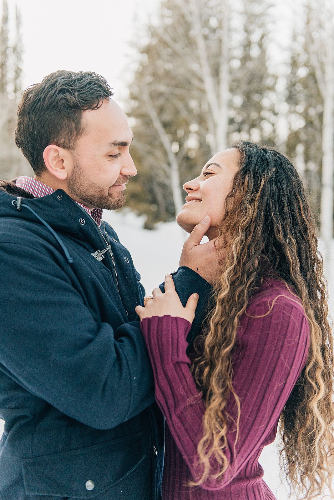 Intimate close-up moment between couple in snowy mountain setting.