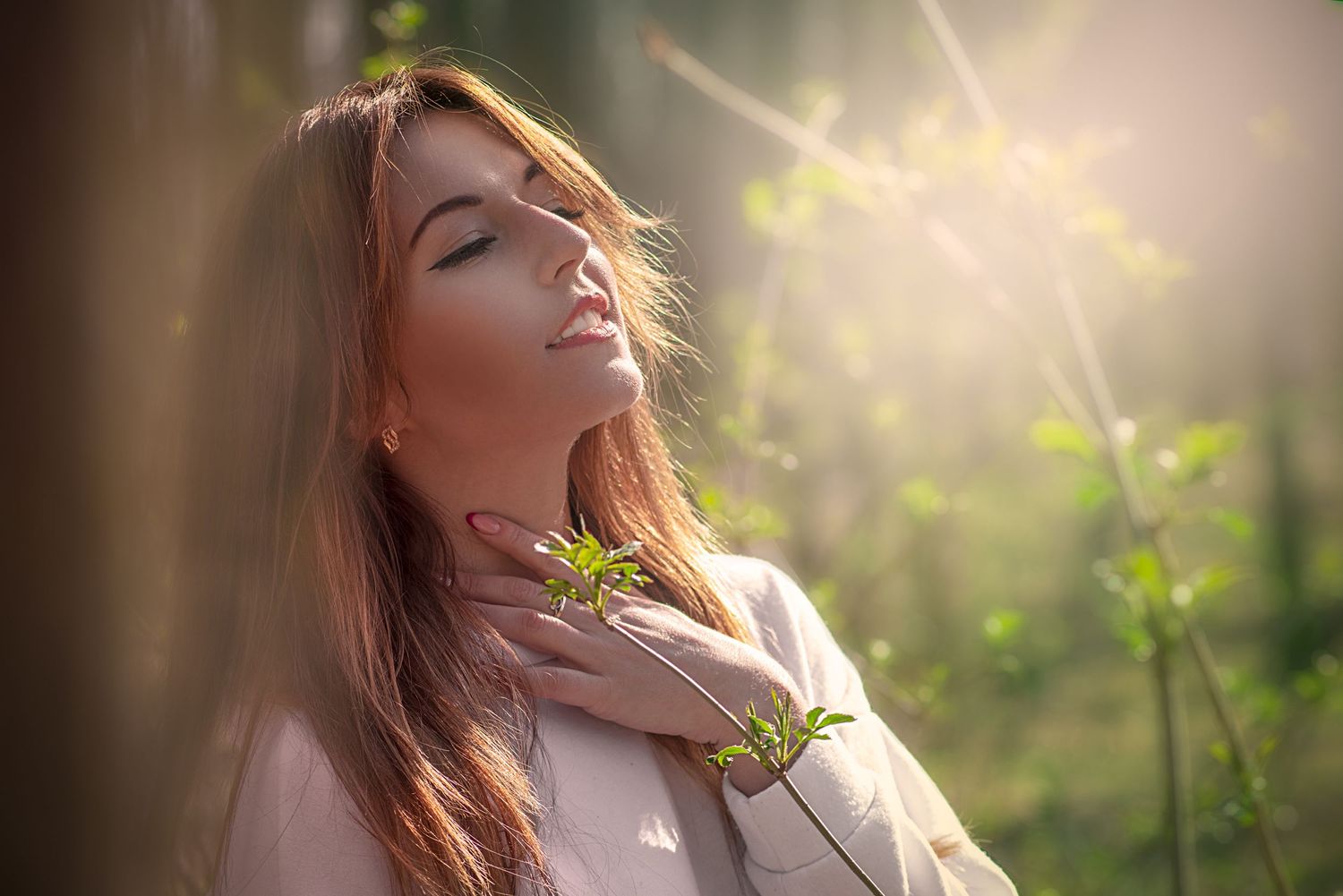 Ethereal backlit portrait with soft golden sunlight and natural elements.