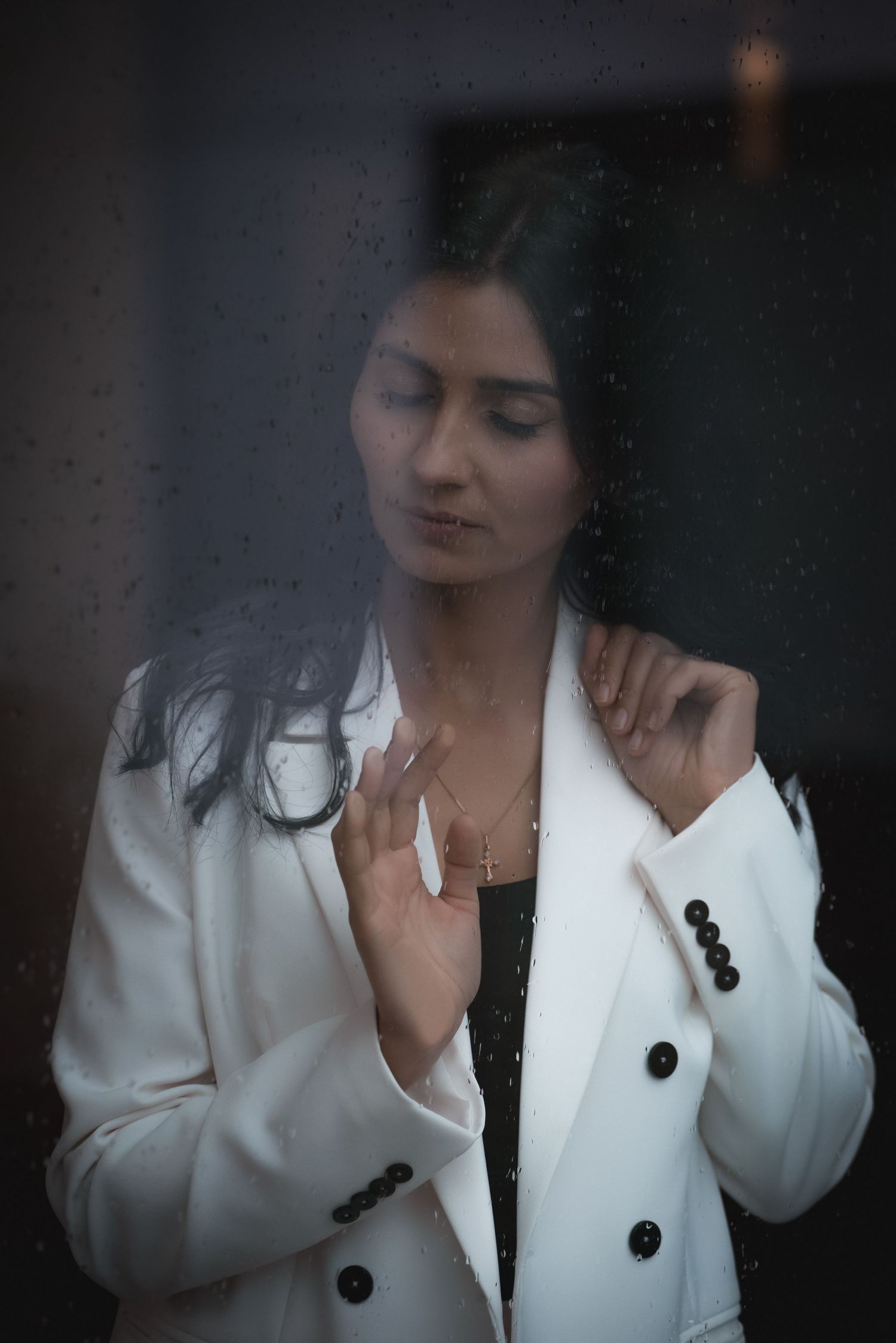 Artistic sequence showing details of a white blazer with black buttons in dim lighting.