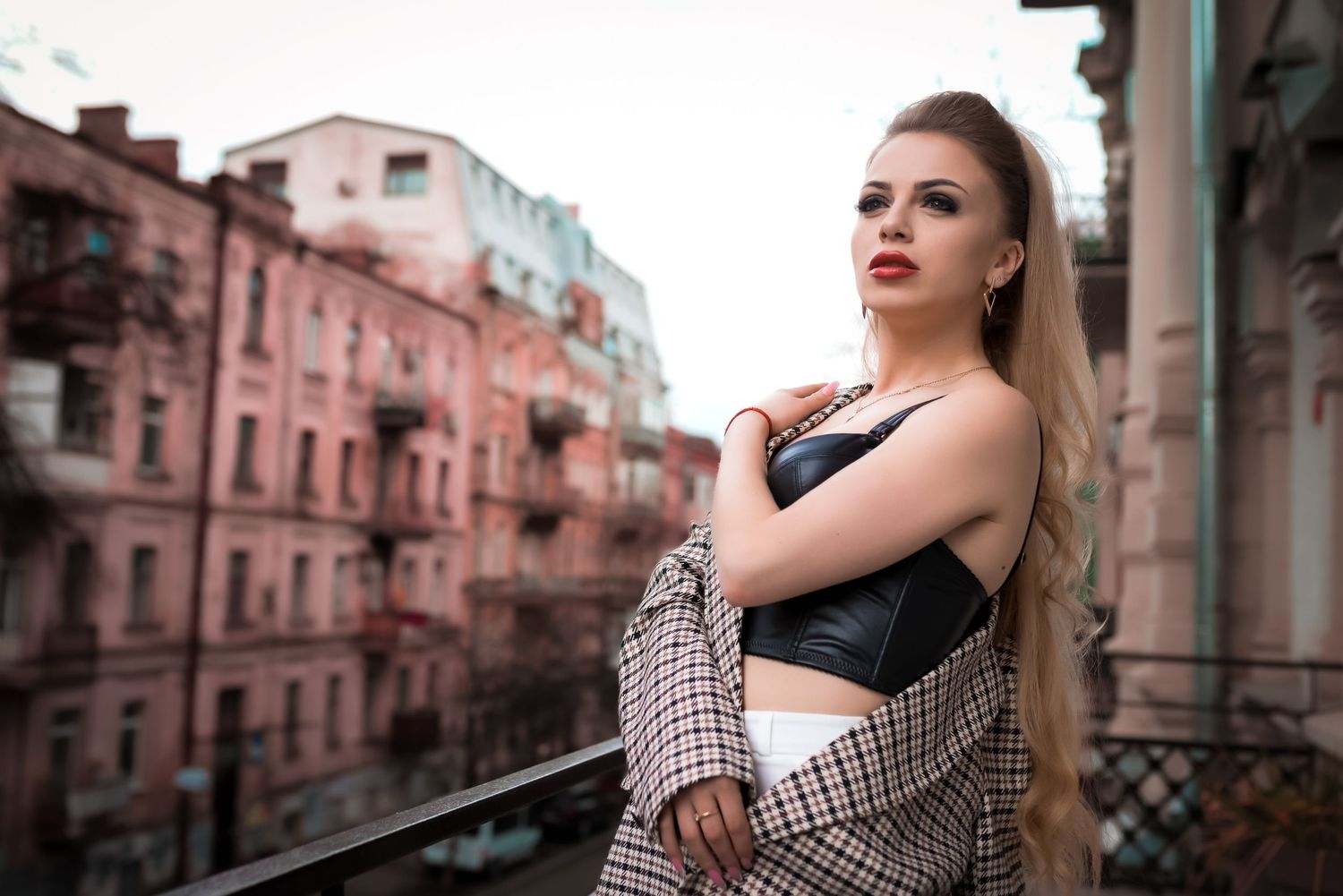 Stylish urban photoshoot with vintage buildings and moody color tones.