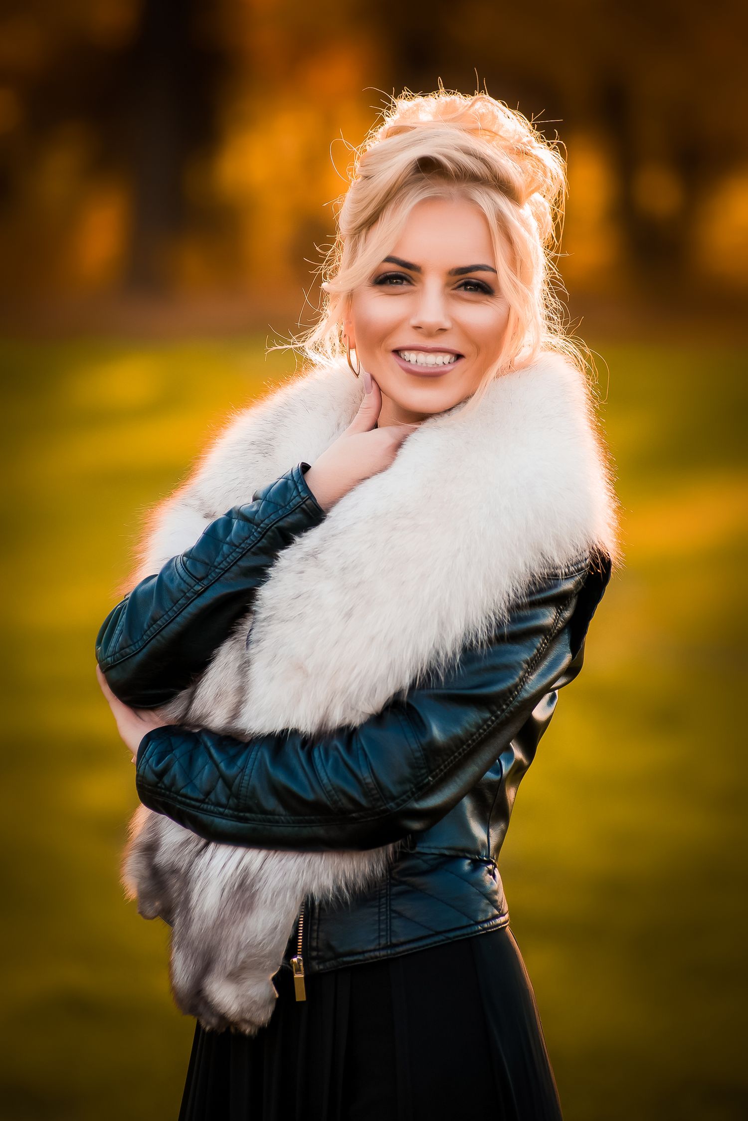 Stylish winter fashion portrait featuring a white fur collar and leather jacket.