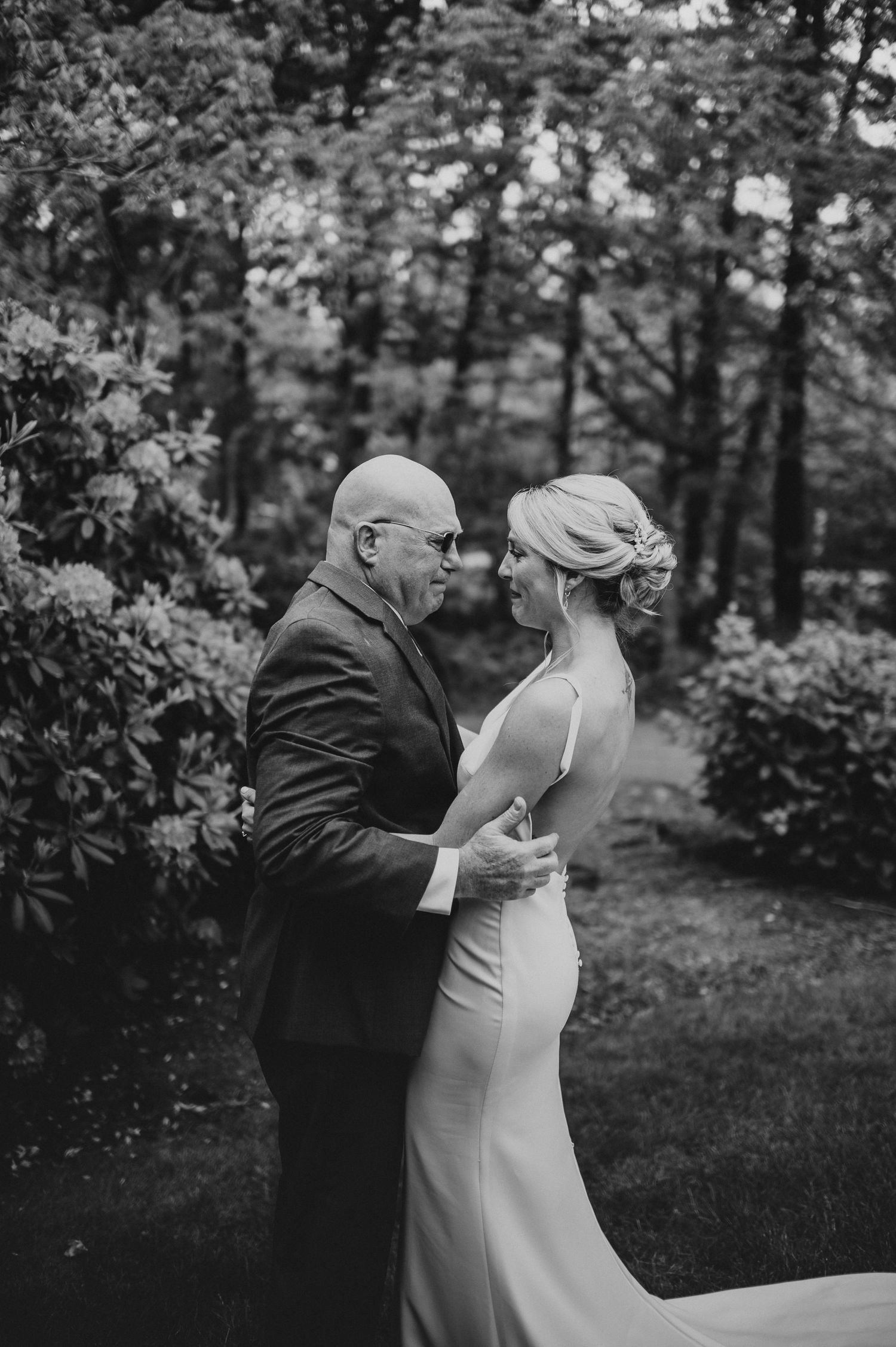 A heartwarming first look moment between a couple in a garden setting captured in black and white.