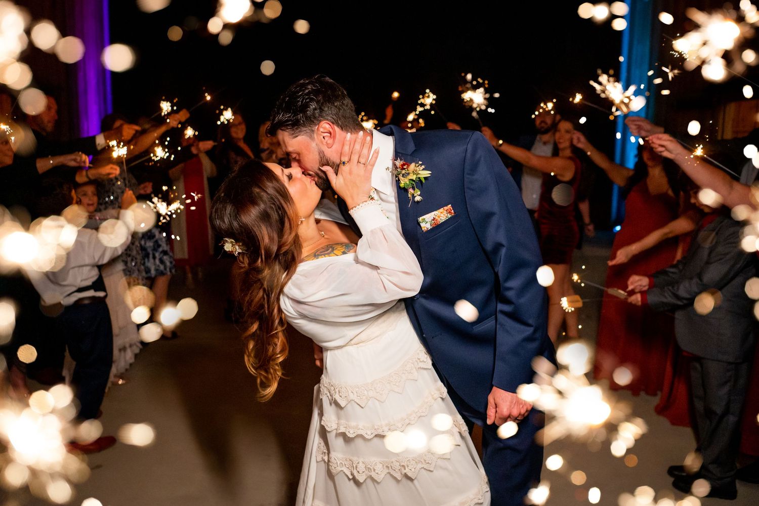 Wedding couple dances under twinkling lights creating a magical bokeh effect at their reception.