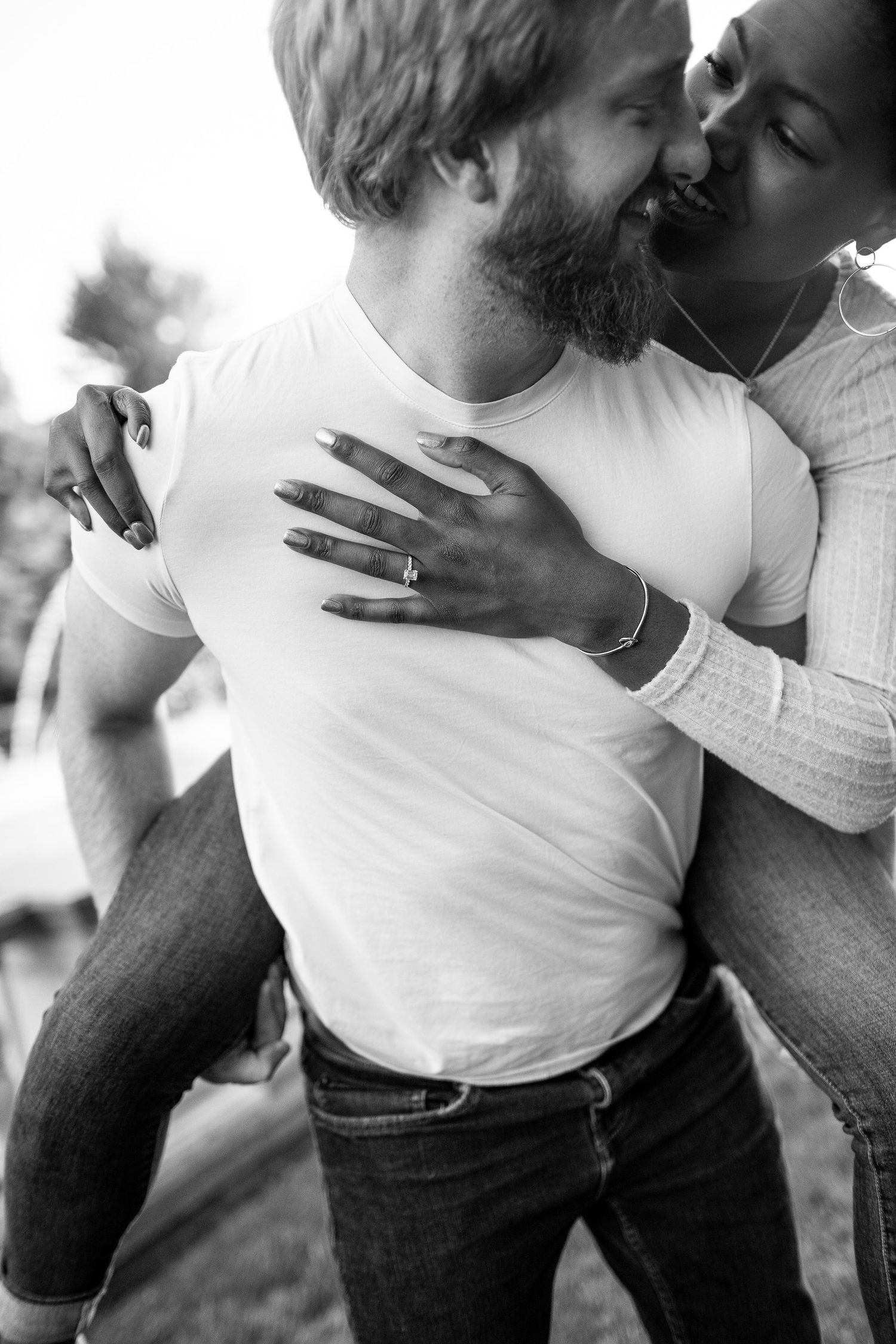Intimate black and white portrait of couple sharing tender moment outdoors.