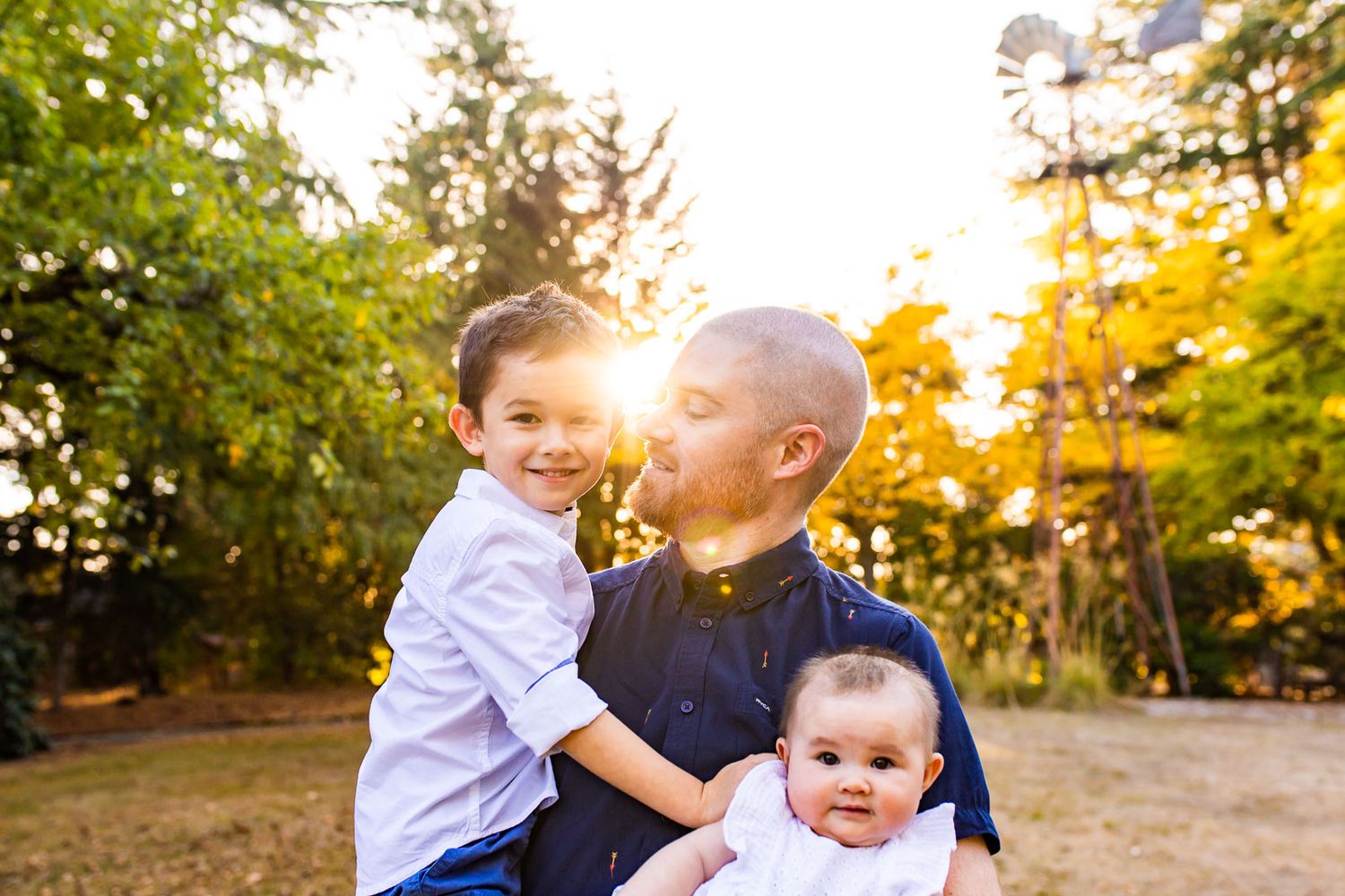 Sunset photo of father and two kids at a local park in Kirkland