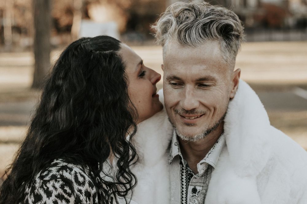 A tender romantic moment captured between a couple in winter coats during golden hour.