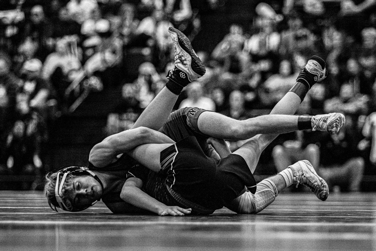 Sequence of wrestling match moves showing athletes grappling on the mat.
