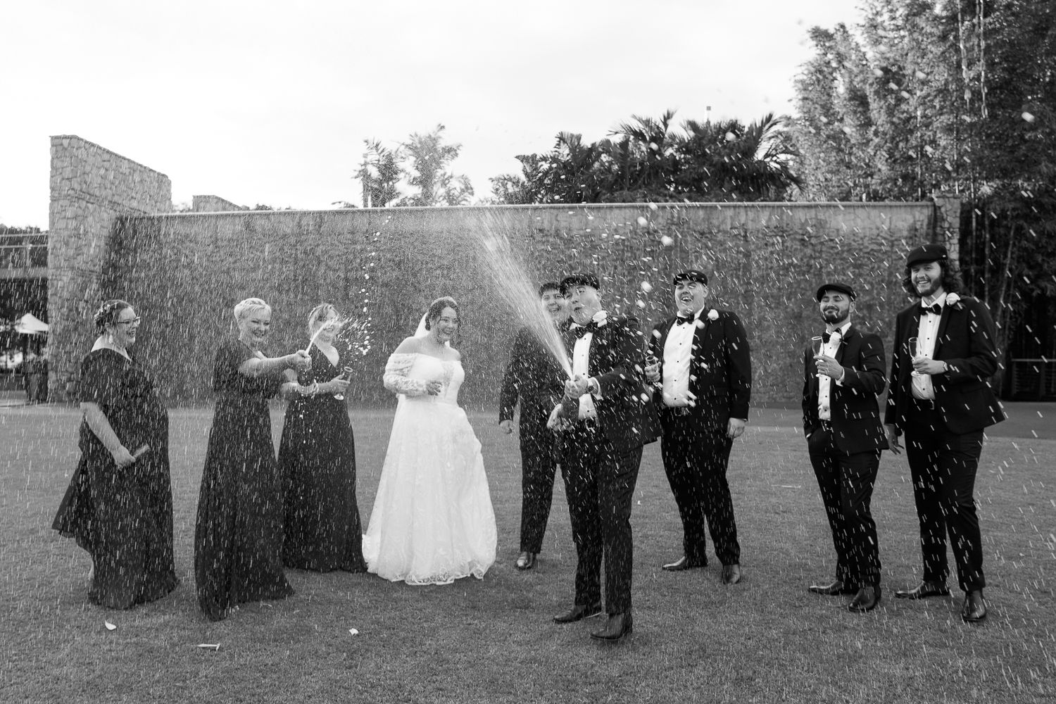 Wedding party popping champagne - by Canberra candid wedding photographer Studio Downe Weddings