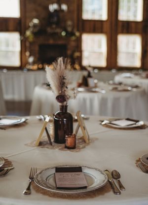 Elegant wedding place settings with lace doilies, amber glassware, and name cards on white tablecloths.