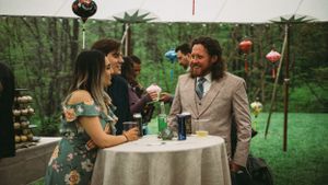 Wedding reception tables set up outdoors with natural forest backdrop.