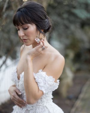 Artistic bridal portrait highlighting delicate lace dress and elegant jewelry.