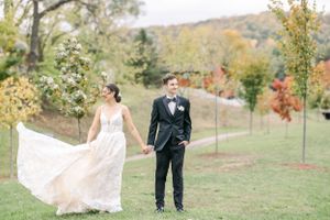 A flowing wedding dress catches the breeze during an autumn outdoor photoshoot.
