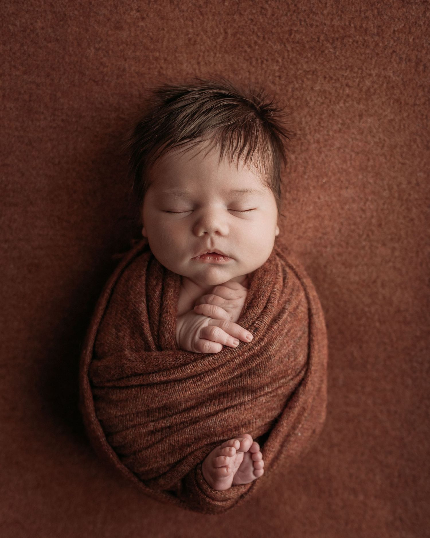 burnt orange baby boy new baby swaddled