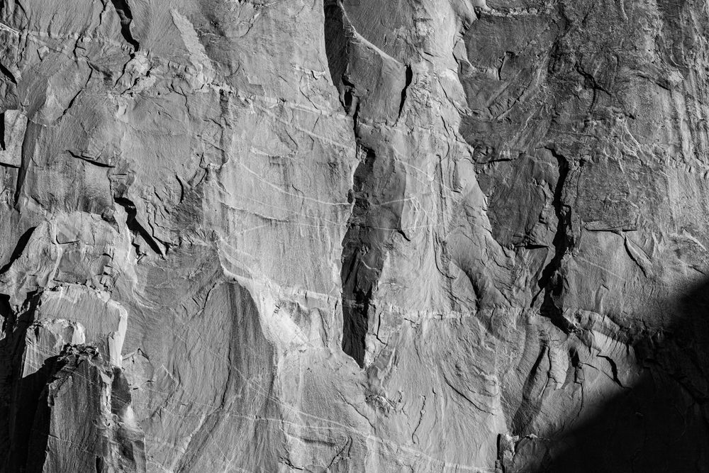 Abstract black and white detail of weathered rock face texture and shadows.